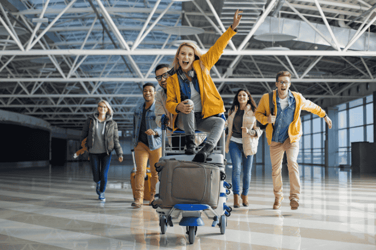 Friends on suitcase rolling through airport
